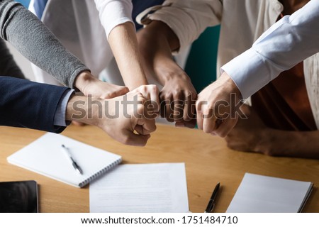Close up image multi racial businesspeople associates putting fists together showing strong support synergy and business loyalty. Symbol of effective teamwork, trust reliability and motivation concept Royalty-Free Stock Photo #1751484710
