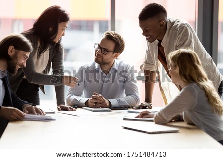 Multi-ethnic staff taking part at briefing group meeting, boss sitting at board room desk listens ideas thoughts creative solutions of workgroup. Team building activity, brainstorming teamwork concept Royalty-Free Stock Photo #1751484713