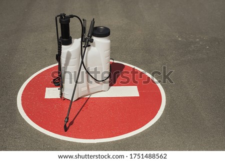 Background image of disinfection equipment standing on red STOP sign outdoors in sunlight, cleaning and prevention concept, copy space