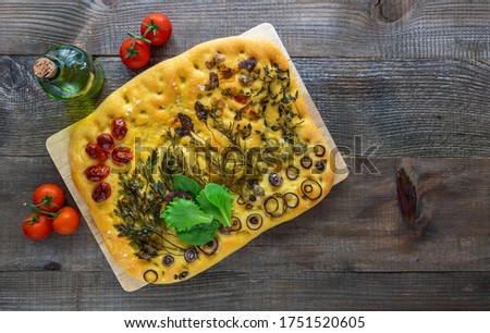 Top view of trendy art garden Focaccia bread with olive oil and tomatoes. wooden table, copy space