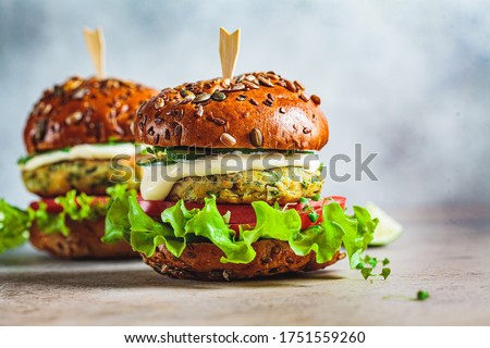 Vegan falafel burger with vegetables and sauce, dark background. Healthy food concept. Royalty-Free Stock Photo #1751559260