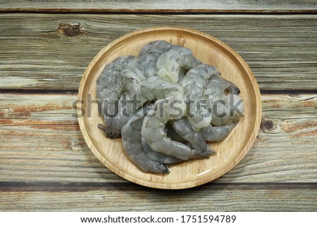 Fresh peeled shrimp on the wooden plate. Preparation raw material in the kitchen. Famous seafood ingredients in Asia.  Royalty-Free Stock Photo #1751594789