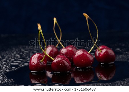 Close-up view of ripe organic cherries with water drops on blue background 