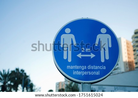 covid 19 safety distance sign, text keep interpersonal distance, blue sky background with buildings