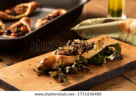 sfiha arabian traditional food baked and stuffed with ground meat with spices with a rack on background