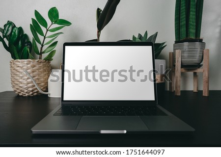 Hipster mockup image on digital laptop and pc notebook technology on table.Showing a mobile phone with blank white screen.Green nature background front view.