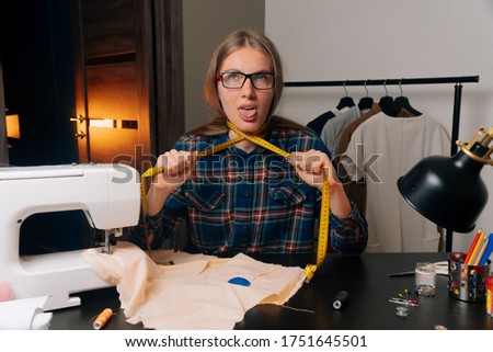 The fashion designer tailor stuck out her tongue, choking herself with a centimeter ribbon. The concept of desperation and the closure of a small business sewing studio.