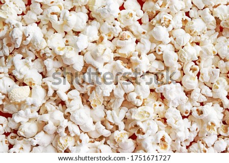 The texture of the popcorn. Scattered salted popcorn. Food background. Fast food popular while watching a movie at the cinema.
