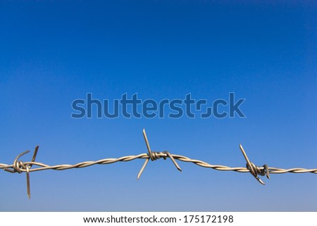 Close up one barbed wire with blue sky background