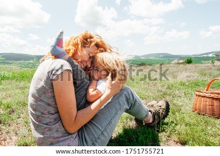 Mom and daughter have fun together in nature, hugging and taking pictures.