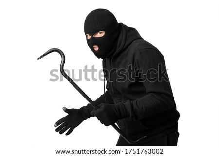 Cat Burglar Concept. Portrait of sneaky masked criminal holding crowbar, copy space, isolated over white studio wall Royalty-Free Stock Photo #1751763002