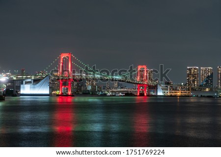 Nightview of Rainbow Bridge, illuminated in red as a sign of "Tokyo Alert (coronavirus alert for Tokyo area)" in Odaiba, Japan.