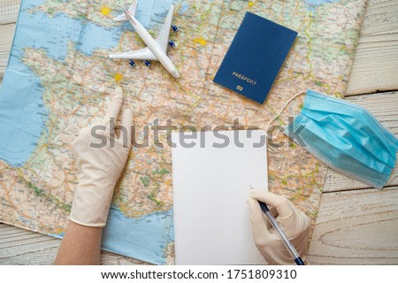 Travel in epidemic quarantine notes template. Table top view with map, plane, notebook, face mask, passport, medical gloves. personal hygiene and protection items in tourism theme. restrictions