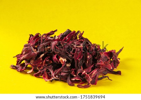 Hibiscus. Reds leaves hibiscus pile tea on a yellow background, side view. Tea leaves karkade.