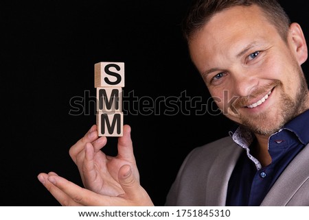 Businessman made word SMM with wood building blocks.