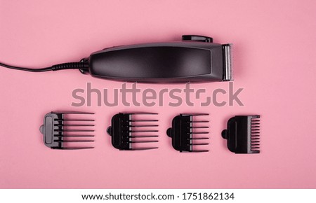 barber clipper for haircuts with nozzles of different sizes on a pink background  top view.
