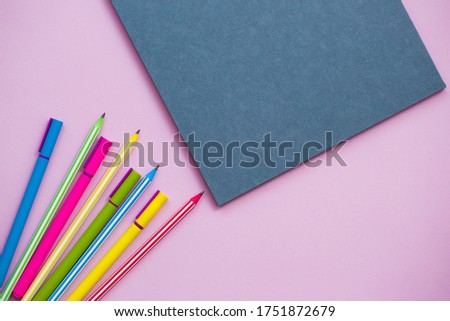 multi-colored pens and pencils with notebook, school stationery, copy space
