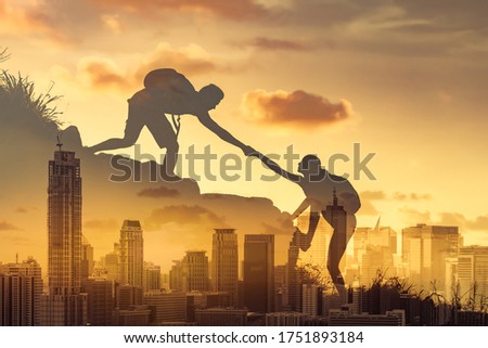 People helping each other hike up a mountain against city background. Giving a helping hand to someone in need, teamwork concept. Double exposure. 
