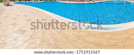 Pool with pure blue water background. Top view of swimming pool and floor texture. Panorama of pool bottom with tile pattern and transparent water. Summer travel and vacation background concept