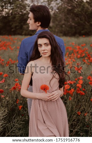 Couple in a poppy field  in summer