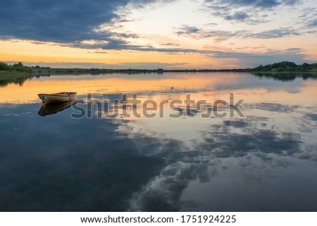 A boat moored on the lake at Skanderborg, Denmark as the sun sets
