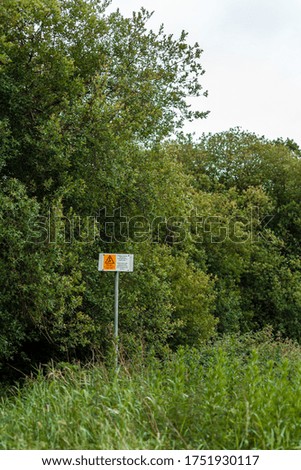 These warning sign are on a path leading through a wood to local fishing pond. They warn of overhead power lines.