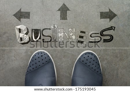 Hand drawn BUSINESS  design word on front of business man feet as concept