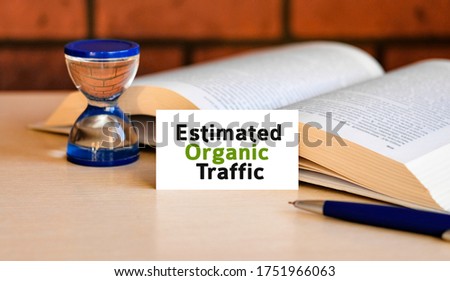 Organic website traffic - business concept text on a white background with a hourglass and an open book
