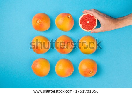 Grapefruits arranged on blue flat background. Creative healthy diet minimal concept.
