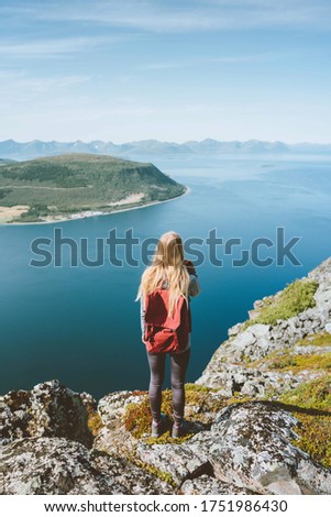 Travel in Norway woman traveler with backpack standing on cliff alone outdoor summer vacations adventure lifestyle solo trip aerial sea fjord landscape  Royalty-Free Stock Photo #1751986430