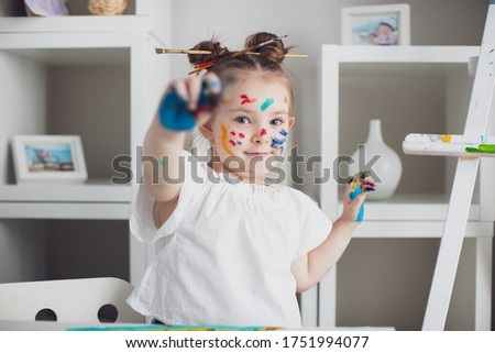Cut girl painting in at her home. Selective focus . High quality photo
