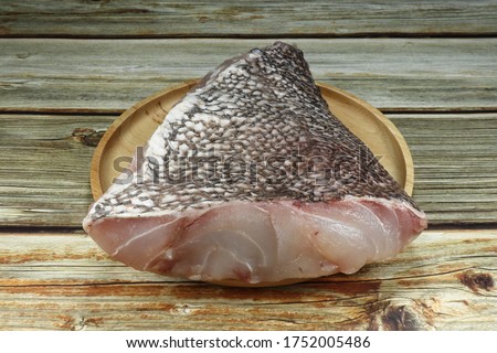 Fresh fish fillet (Grouper fish or King mackerel) on the wooden plate. Famous raw seafood material in Asia kitchen.  Royalty-Free Stock Photo #1752005486