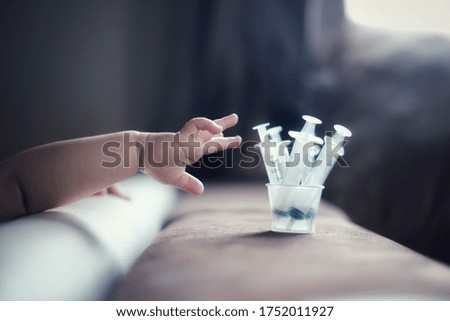 Children's hands and syringes for liquid medicine. Concept for medical and background.