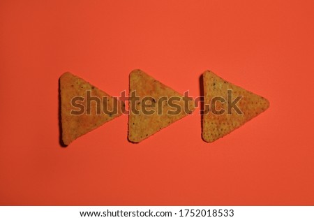 Geometrically organised corn chips on a bright background. Food knolling picture of corn chips.