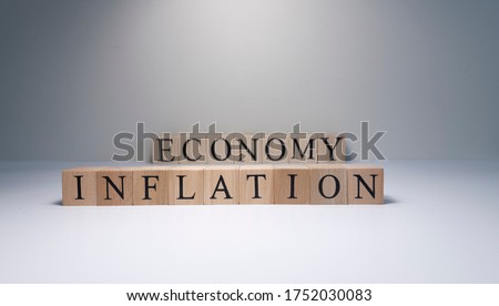 Inflation text from wooden cubes. With spot light in the studio and white background.