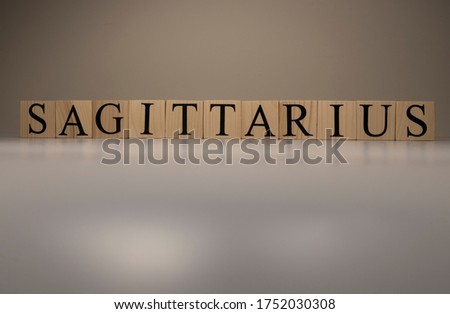 Sagittarius word on wooden cubes on white background. Photographed in the studio and in spot light. Zodiac or star signs consists of 12 horoscopes.