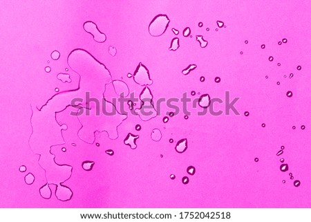 Water drops on smooth surface, pink background