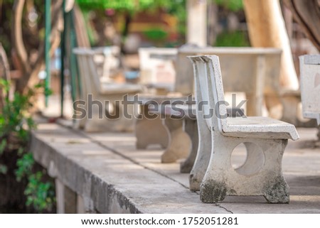The blurry background of the chairs made of cement, to sit in the park or inside various temples, to facilitate the people who use the service