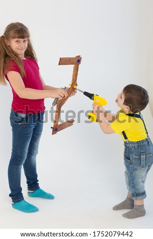 a girl and boy make the number two from a wooden stick