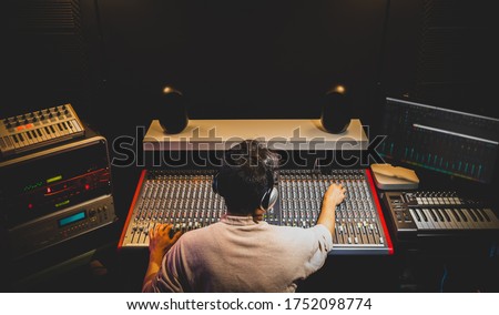 back of asian producer, dj, sound engineer mixing music in recording, broadcasting studio