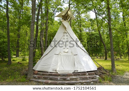 Native American wigwam made of fabric covered branches in forest Royalty-Free Stock Photo #1752104561