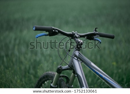 view of mountain bike stands in grass field. leisure time and cycling in freedom. outdoor bicycling