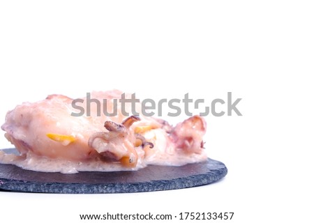 A picture of "ketupat sotong" on slate table white background. Glutinous rice stuffed in squid that is famous East Coast of Malaysia.