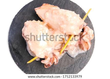 A flatlay closeup picture of "ketupat sotong" on slate table white background. Glutinous rice stuffed in squid that is famous East Coast of Malaysia.