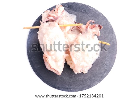 A flatlay picture of "ketupat sotong" on slate table white background. Glutinous rice stuffed in squid that is famous East Coast of Malaysia.
