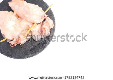 A flatlay picture of "ketupat sotong" on slate table with copyspace white background. Glutinous rice stuffed in squid that is famous East Coast of Malaysia.