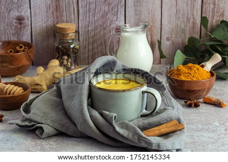 Golden turmeric milk with cinnamon, honey, and ginger. Ayurveda treatment. Alternative medicine concept. Royalty-Free Stock Photo #1752145334