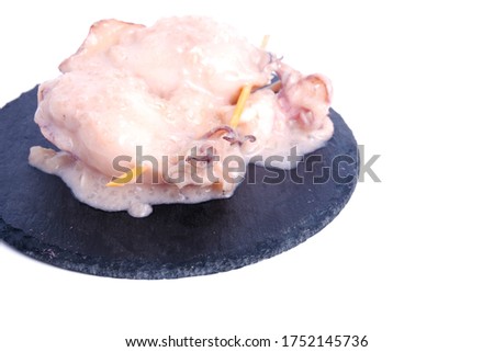 A picture of "ketupat sotong" on slate plate on copyspace white background. Glutinous rice stuffed in squid that is famous East Coast of Malaysia.