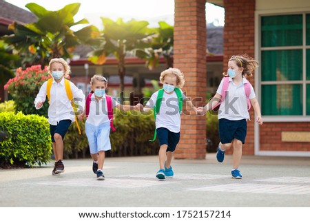 School child wearing face mask during corona virus and flu outbreak. Boy and girl going back to school after covid-19 quarantine and lockdown. Group of kids in masks for coronavirus prevention.  Royalty-Free Stock Photo #1752157214
