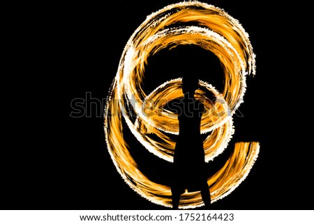 Amazing traditional fire dancing show at night in Thailand. Also known as fire spinning and twirling. Captured with long exposure technique cause stunning fire circle. Isolated on black background
